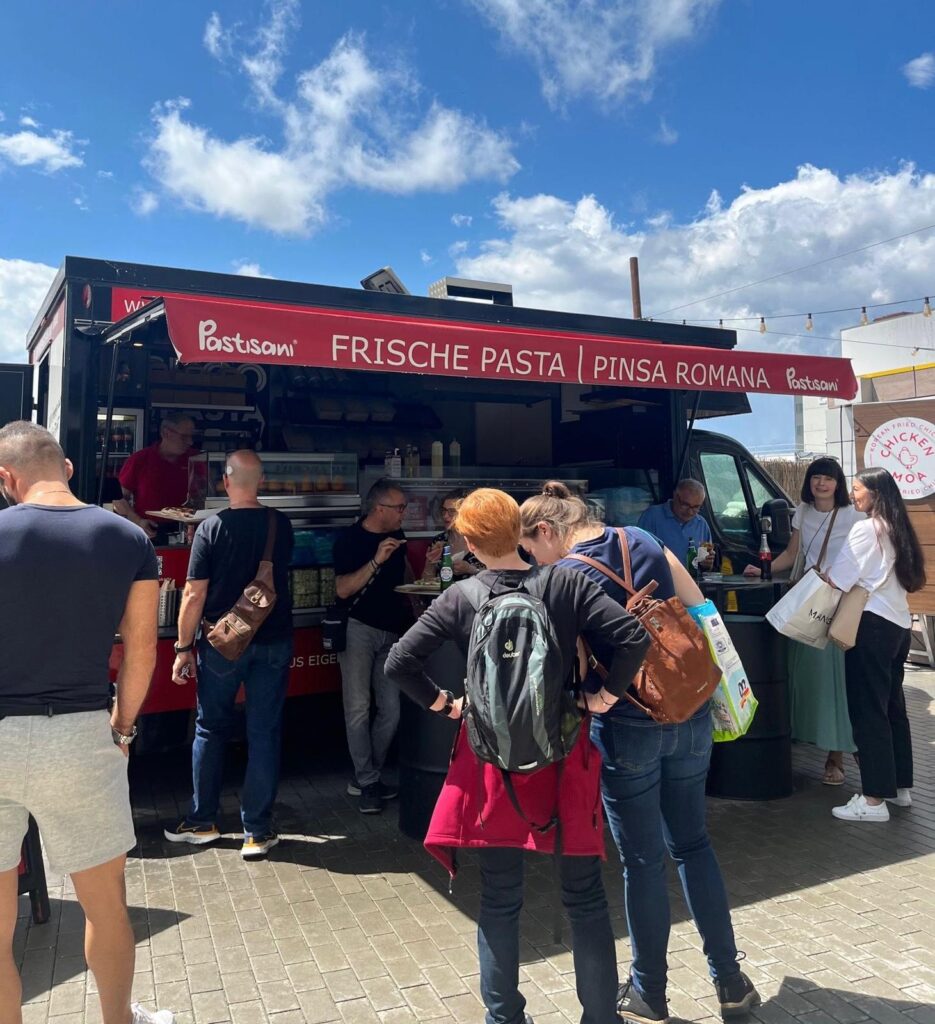 Gäste am Pasta- und Pinsa-Foodtruck bei einem Sommerevent