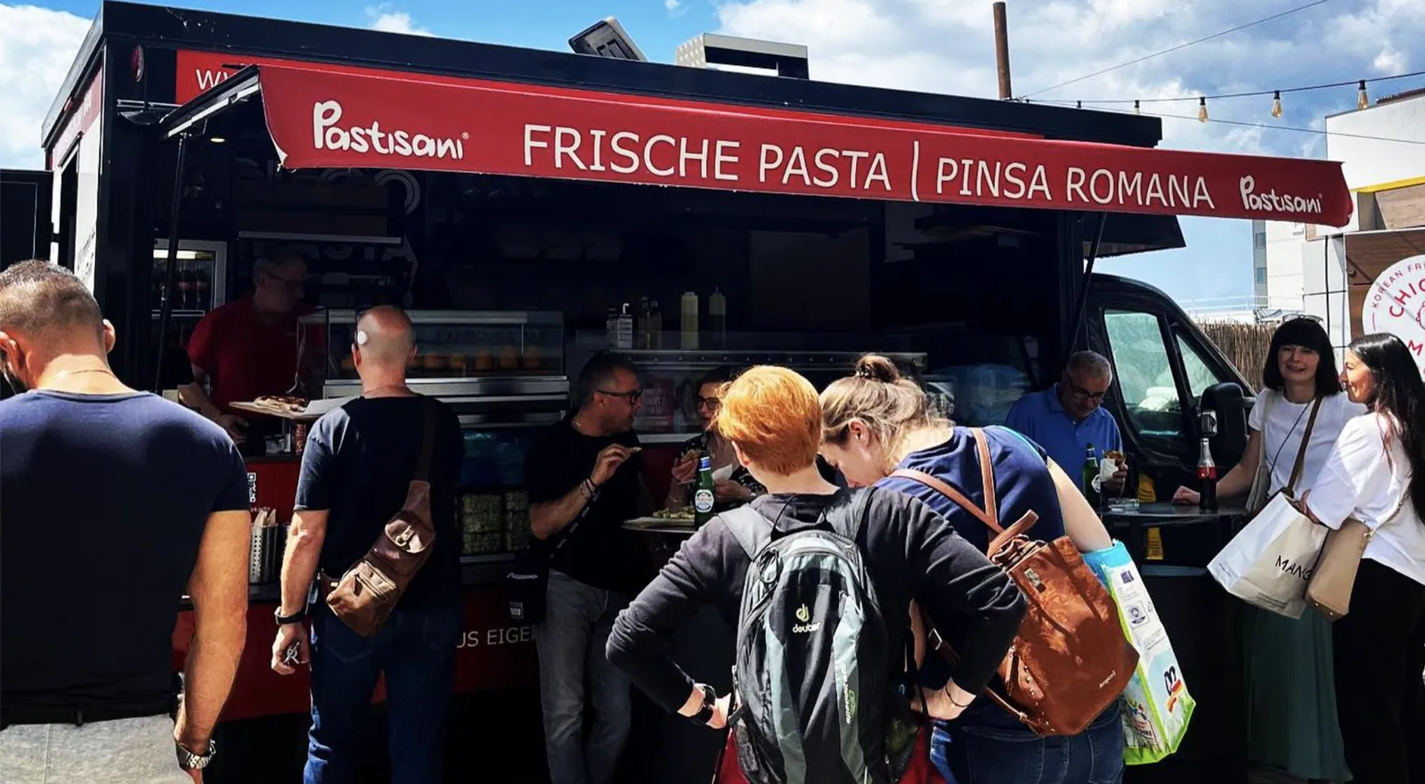 Gäste am Pastisani-Foodtruck mit frischer Pasta und Pinsa beim Event